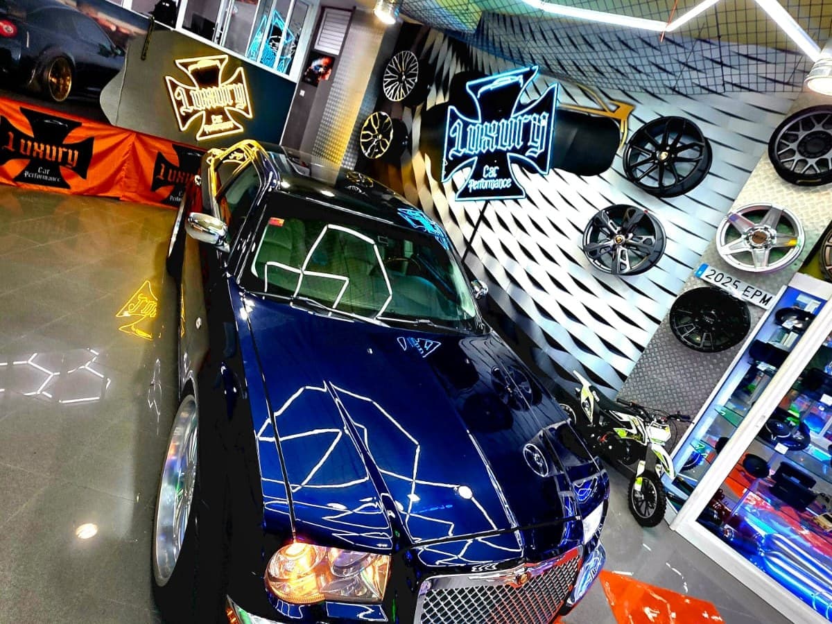 Chrysler 300 azul junto al expositor de llantas en el showroom